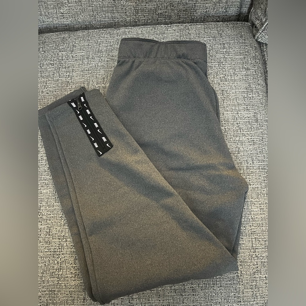 grey nike joggers, zips at the end, size small,